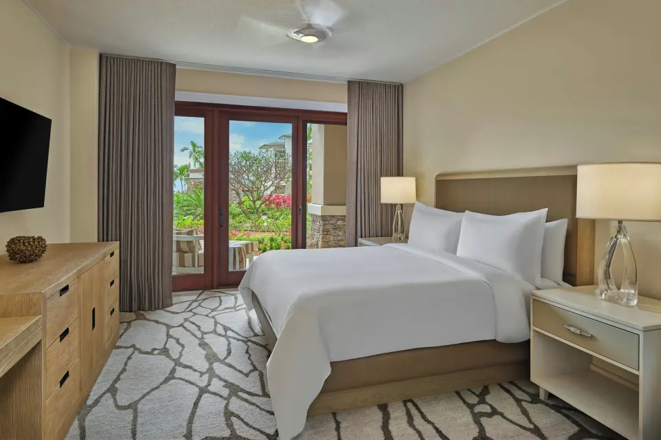 Second bedroom with bed and garden-view doors in a 3 Bedroom Residence at The Resort at Kapalua Bay, Maui