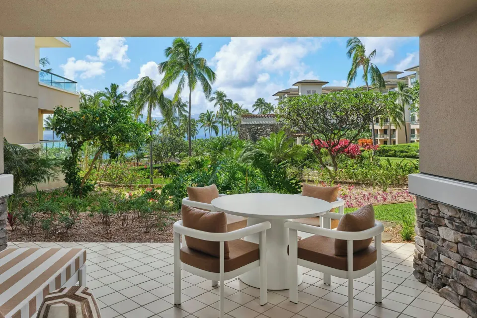 Covered lanai table with garden view at a 3 Bedroom Residence Lanai Garden View at The Resort at Kapalua Bay, Maui