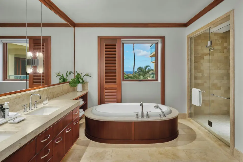 Bathroom with freestanding tub, vanity and separate shower with ocean view window at The Resort at Kapalua Bay, Maui