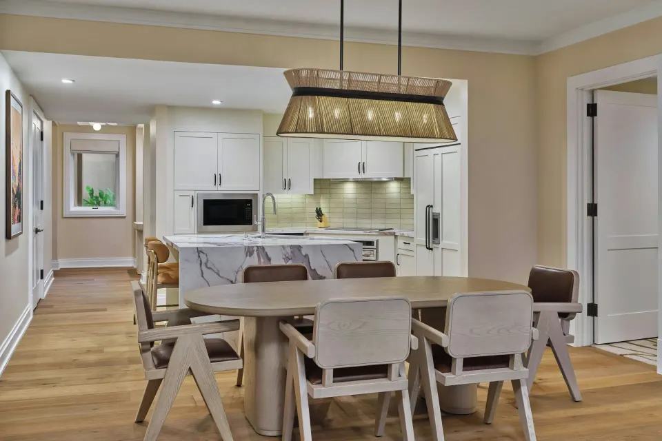 Dining table and open kitchen with island in a residence at The Resort at Kapalua Bay, Maui