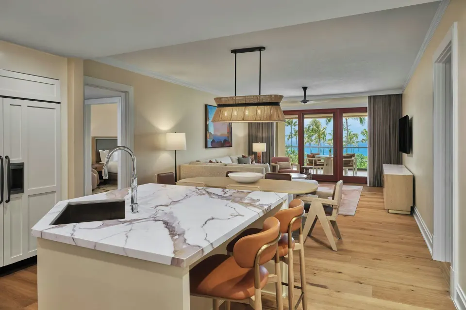 Open-plan kitchen island looking toward living room and lanai in a residence at The Resort at Kapalua Bay, Maui