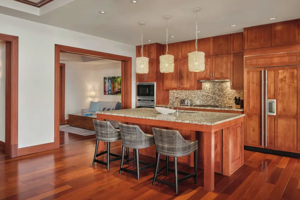 Residence kitchen with island seating and wood cabinetry at The Resort at Kapalua Bay, Maui