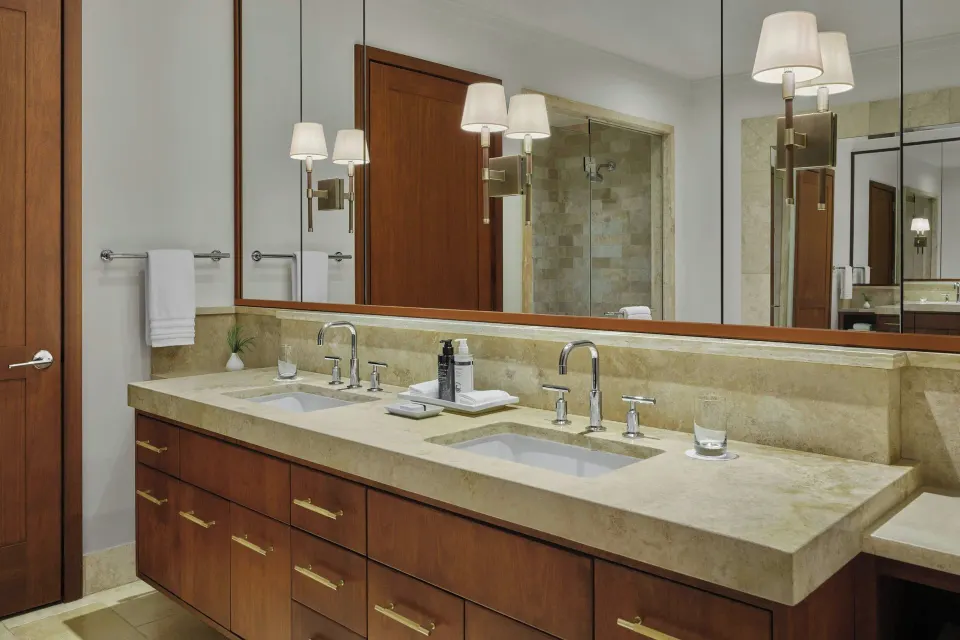 Double vanity with marble countertop and mirrors in guest bathroom at The Resort at Kapalua Bay, Maui
