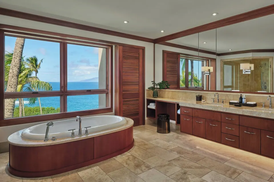 Ocean-view bathroom with freestanding tub and large window at The Resort at Kapalua Bay, Maui