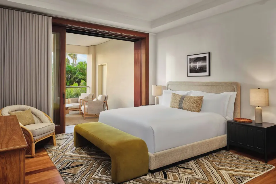 King bedroom with green bench and lanai seating at The Resort at Kapalua Bay, Maui