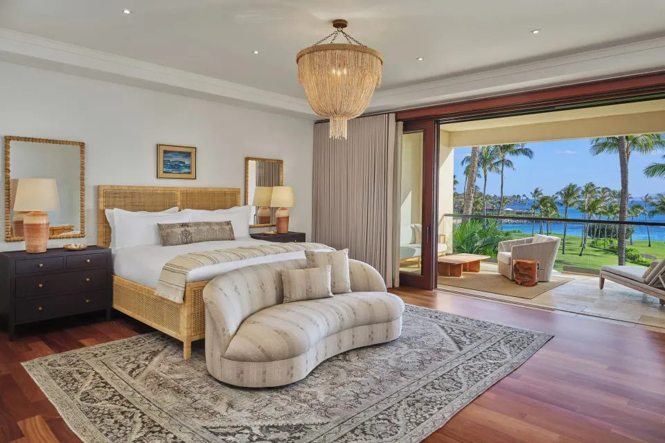 Oceanfront grand bedroom with king bed and curved sofa at The Resort at Kapalua Bay, Maui