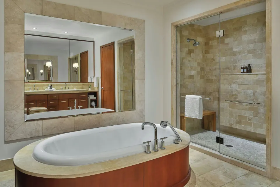 Bathroom with oval soaking tub and glass shower in Grand Lanai Four-Bedroom at The Resort at Kapalua Bay, Maui