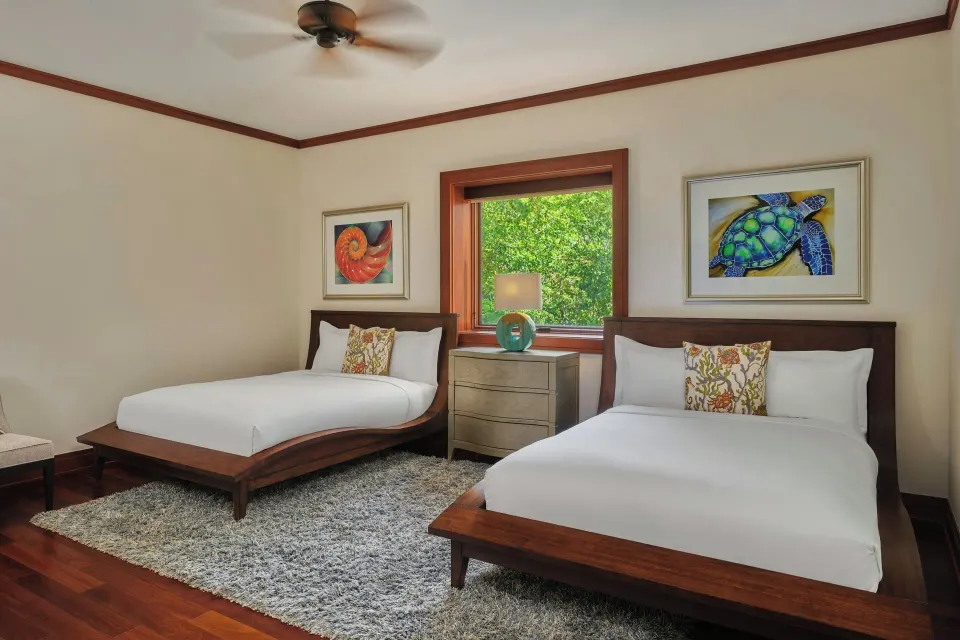 Twin beds with window and rug in guest bedroom at The Resort at Kapalua Bay, Maui