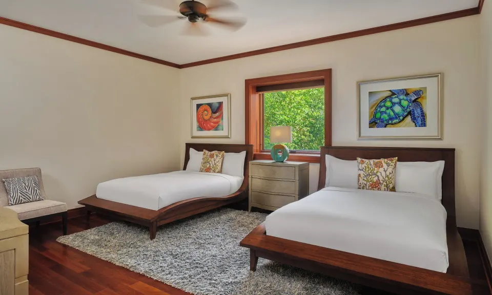 Bedroom with two beds and tropical artwork at The Resort at Kapalua Bay, Maui