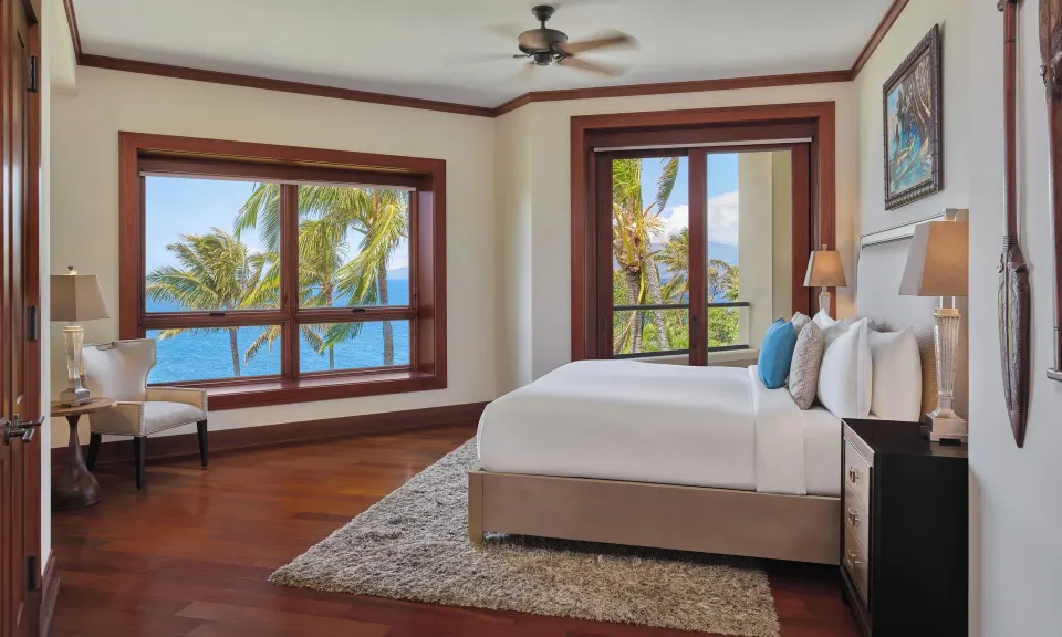 Secondary king bedroom with large windows and ocean view at The Resort at Kapalua Bay, Maui