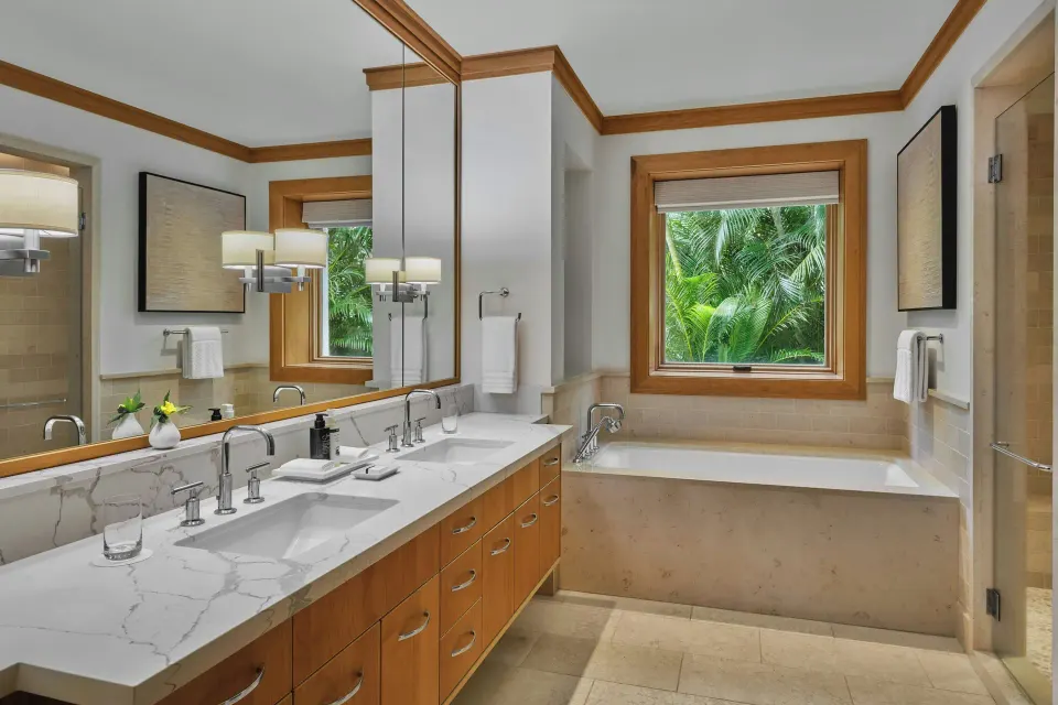 Bathroom with double vanity and soaking tub framed by garden window at The Resort at Kapalua Bay, Maui