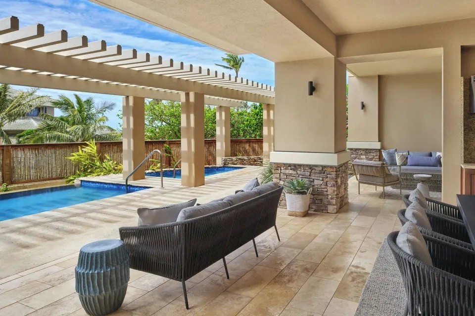 Covered terrace with outdoor sofas and pool glimpse at The Resort at Kapalua Bay, Maui