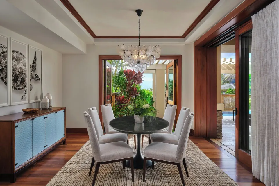 Dining area with round table and chandelier opening to a patio at The Resort at Kapalua Bay, Maui