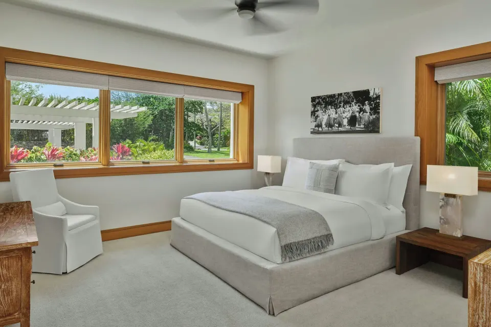 King bed and outdoor seating visible through open doors in a Signature 3 Bedroom Residence at The Resort at Kapalua Bay, Maui