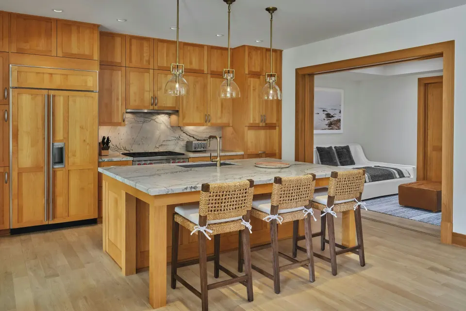 Open-plan kitchen with island and stools beside a bedroom at The Resort at Kapalua Bay, Maui
