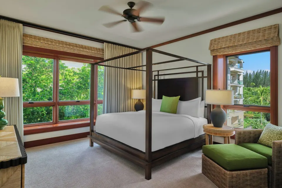 Four-poster king bed in bedroom with corner windows at The Resort at Kapalua Bay, Maui