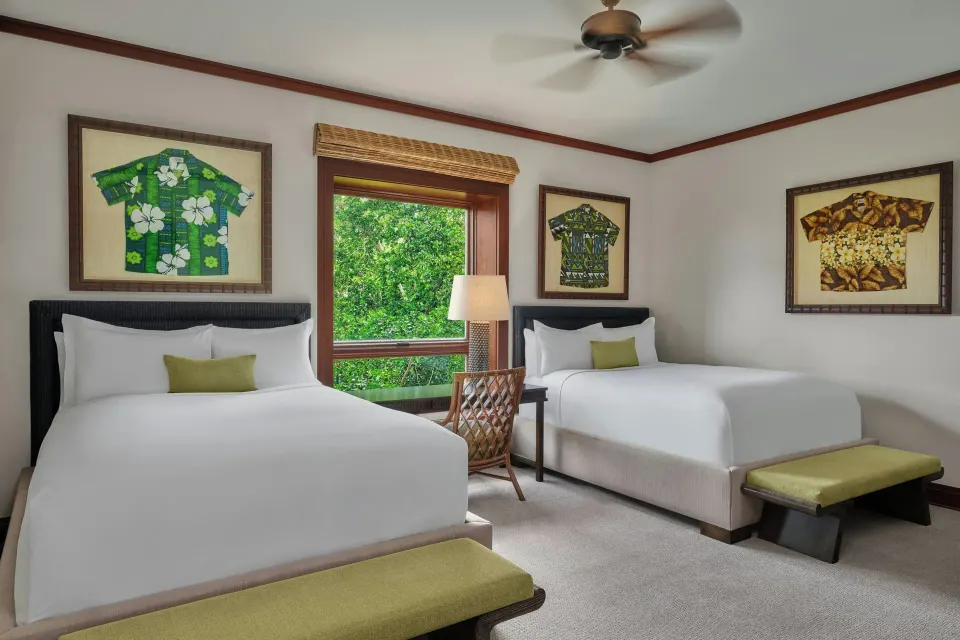 Twin beds in a second bedroom with tropical artwork at The Resort at Kapalua Bay, Maui