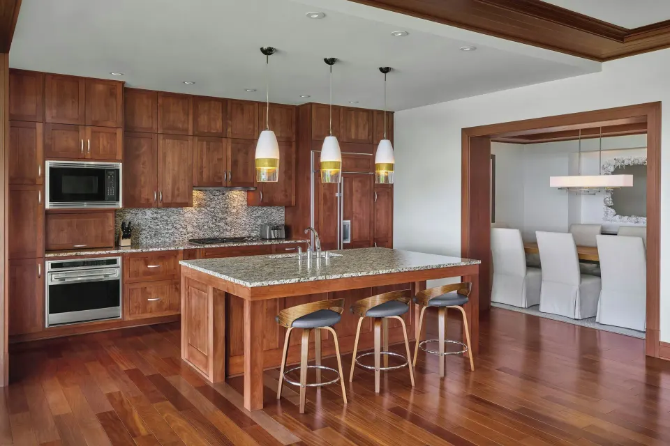 Full kitchen with island and pendant lights in residence at The Resort at Kapalua Bay, Maui