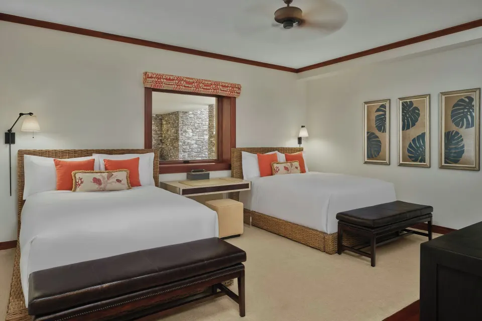 Guest bedroom with two double beds and artwork at The Resort at Kapalua Bay, Maui