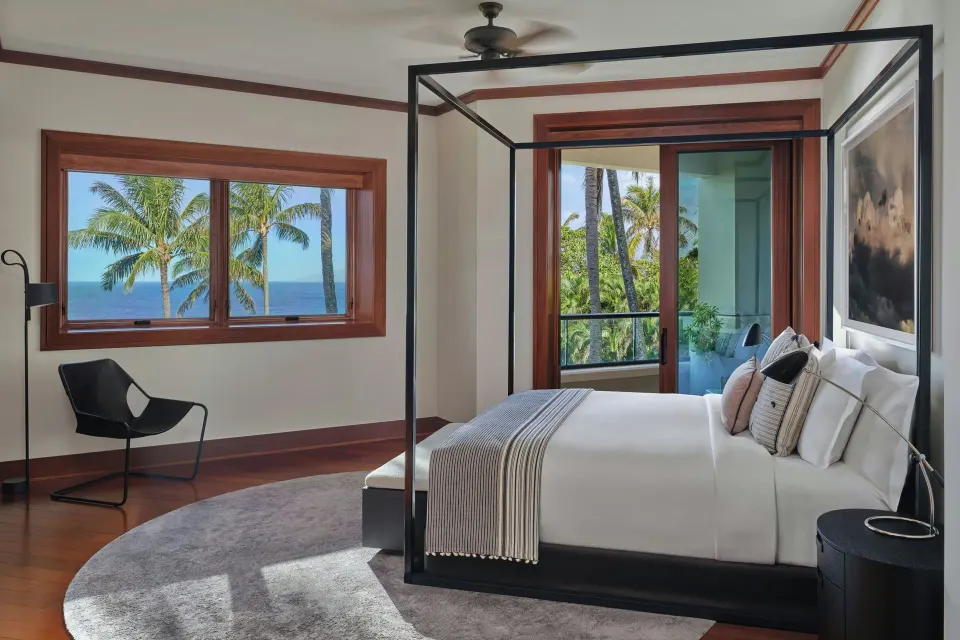Canopy bed in a bedroom with ocean view through a window at The Resort at Kapalua Bay, Maui