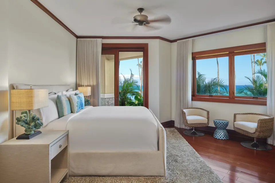 Bedroom with king bed and corner windows revealing ocean views at The Resort at Kapalua Bay, Maui