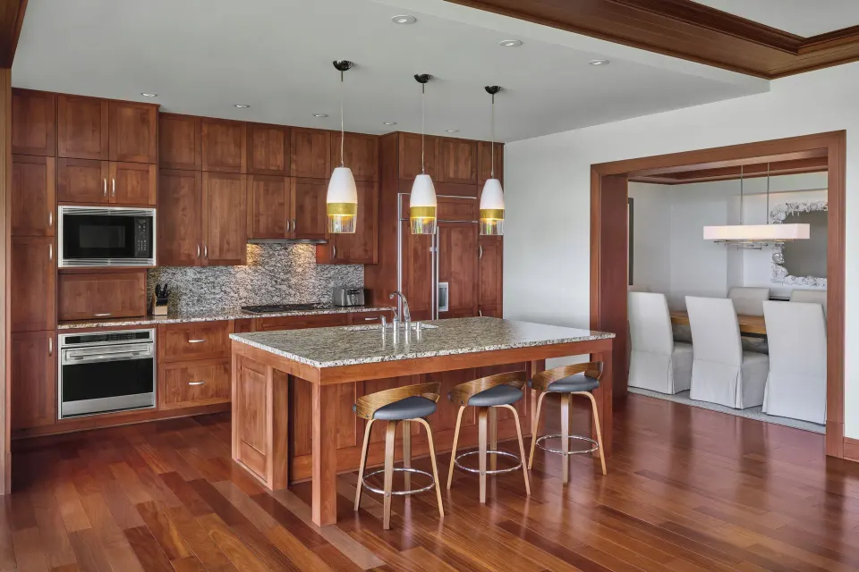 Kitchen with island and wood cabinetry in a Signature 4 Bedroom Residence at The Resort at Kapalua Bay, Maui