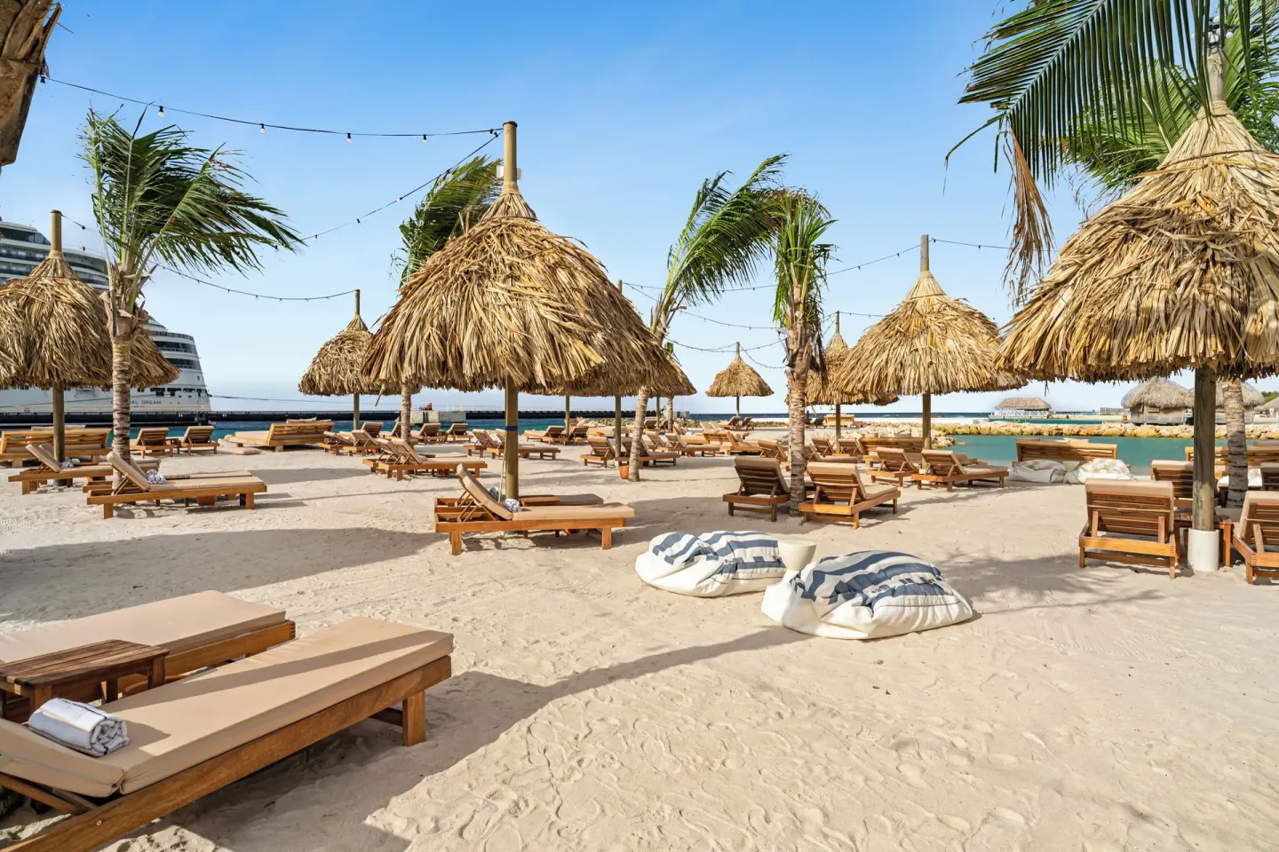 Sandy beach with palapas and wooden loungers at The Rif at Mangrove Beach Corendon Curacao, Curio.