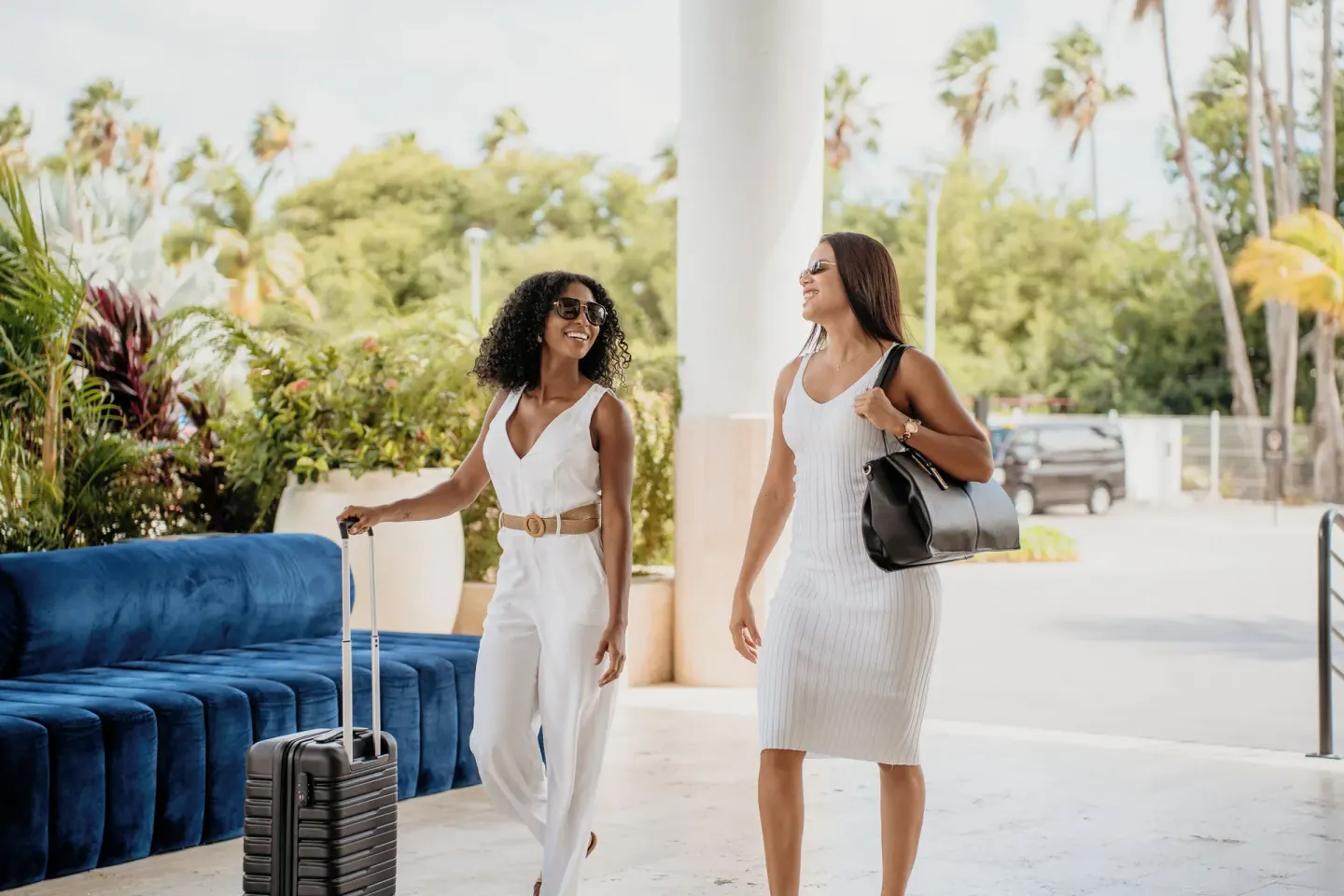Two guests arriving with luggage near the lobby at The Rif at Mangrove Beach Corendon Curacao, Curio.