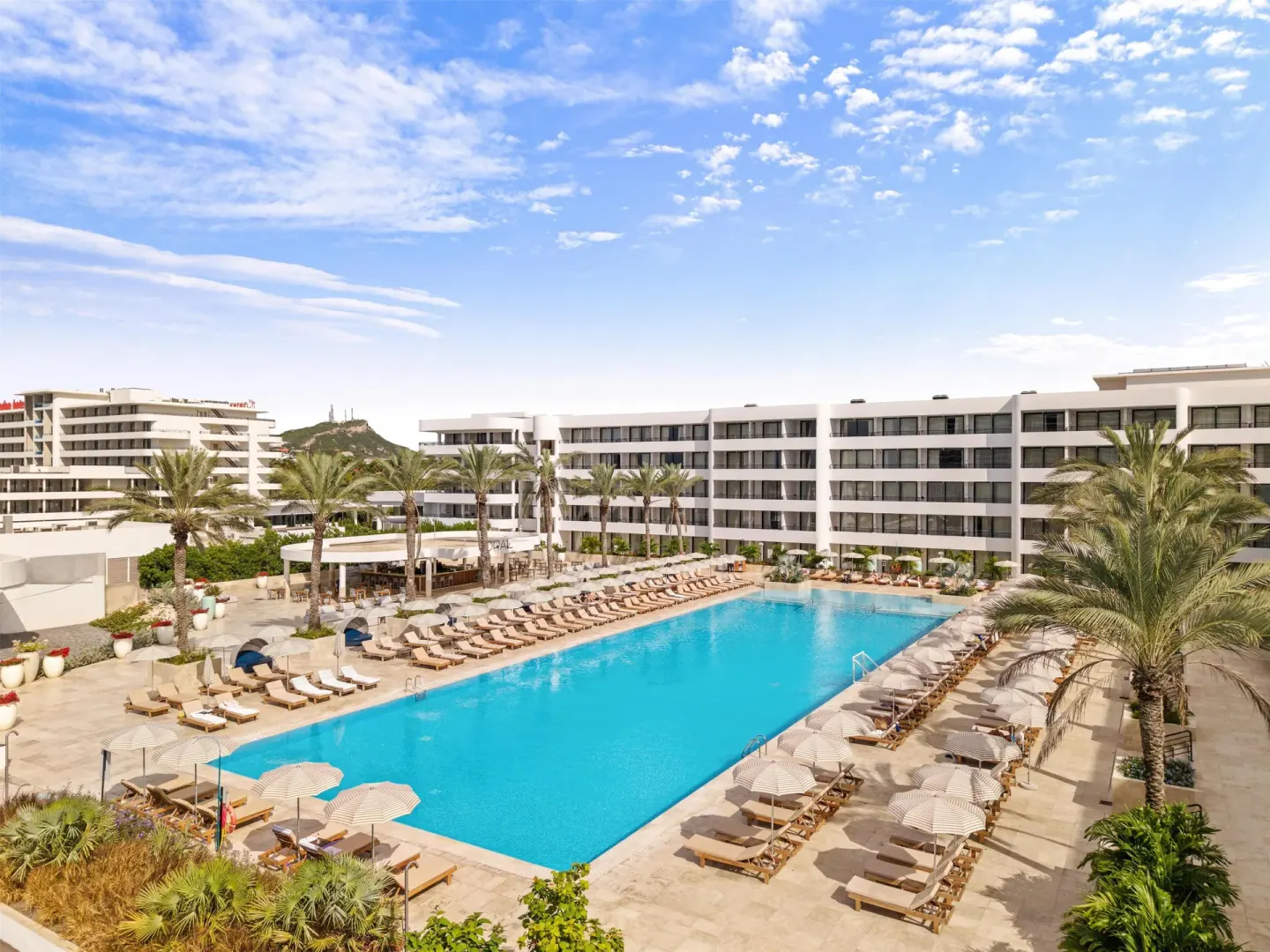 Large resort pool with loungers and palm trees at The Rif at Mangrove Beach Corendon Curacao, Curio.