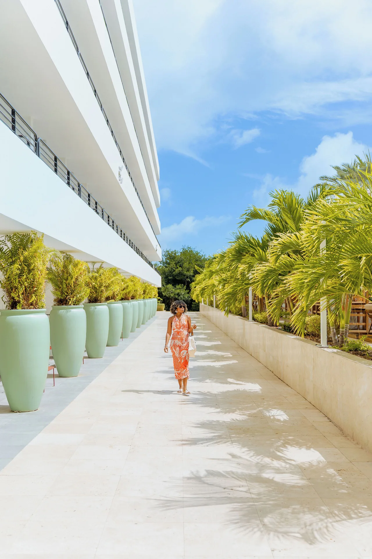 Palm-lined walkway beside the resort building at The Rif at Mangrove Beach Corendon Curacao, Curio.