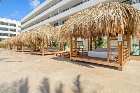 Poolside cabanas with thatched roofs at The Rif at Mangrove Beach Corendon Curacao, Curio.