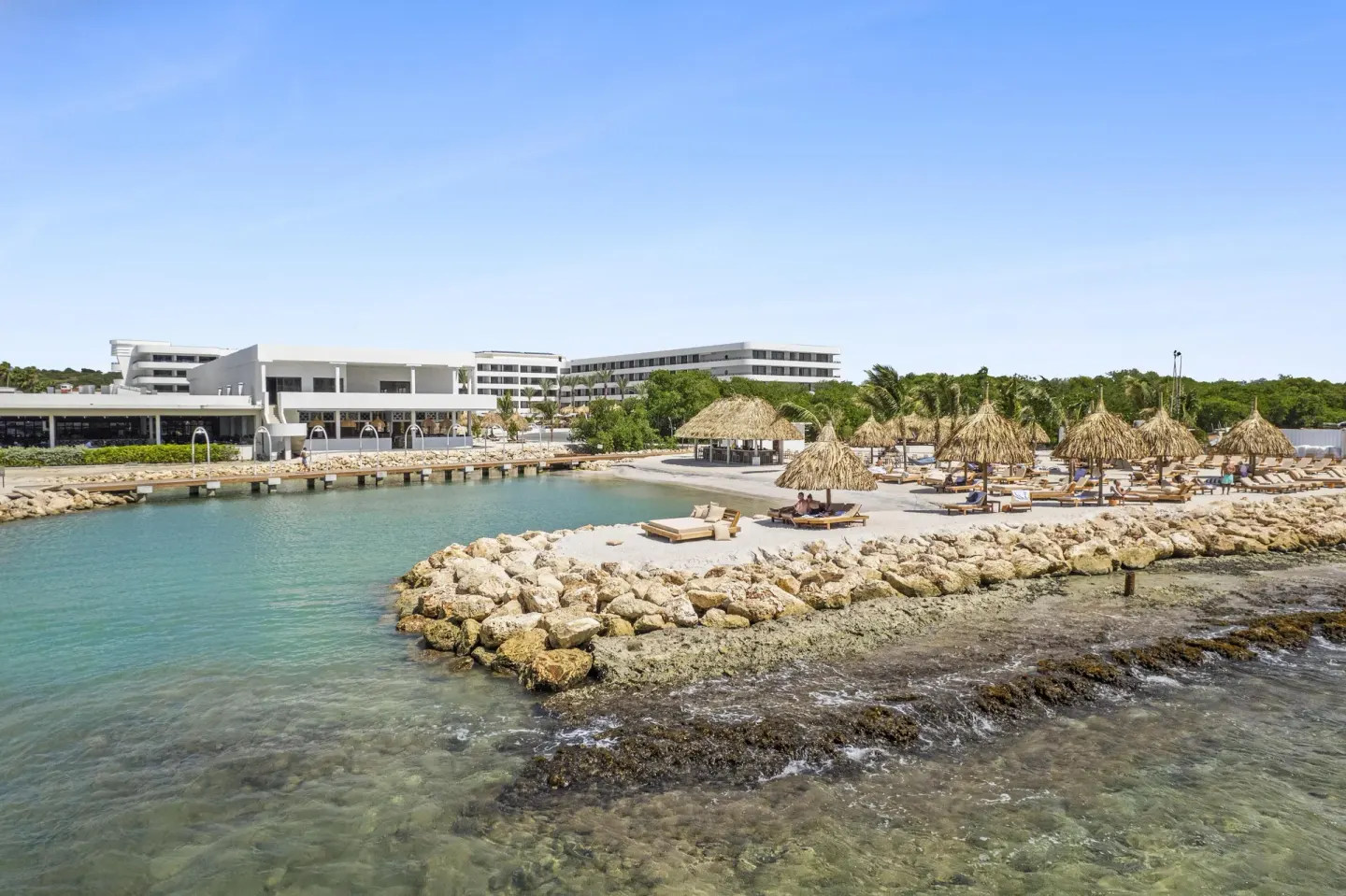Resort shoreline with palapas and turquoise water at The Rif at Mangrove Beach Corendon Curacao, Curio.