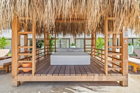 Thatched cabana daybed with pillows at The Rif at Mangrove Beach Corendon Curacao, Curio.