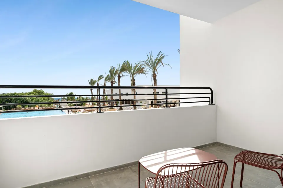 Balcony seating with palm and ocean views from The Rif at Mangrove Beach Corendon Curacao, Curio.