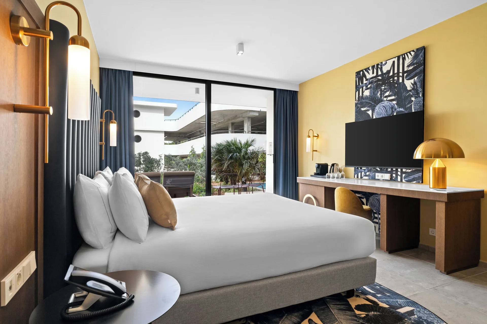 Deluxe Room king bed with TV wall and patio doors at The Rif at Mangrove Beach Corendon Curacao, Curio.