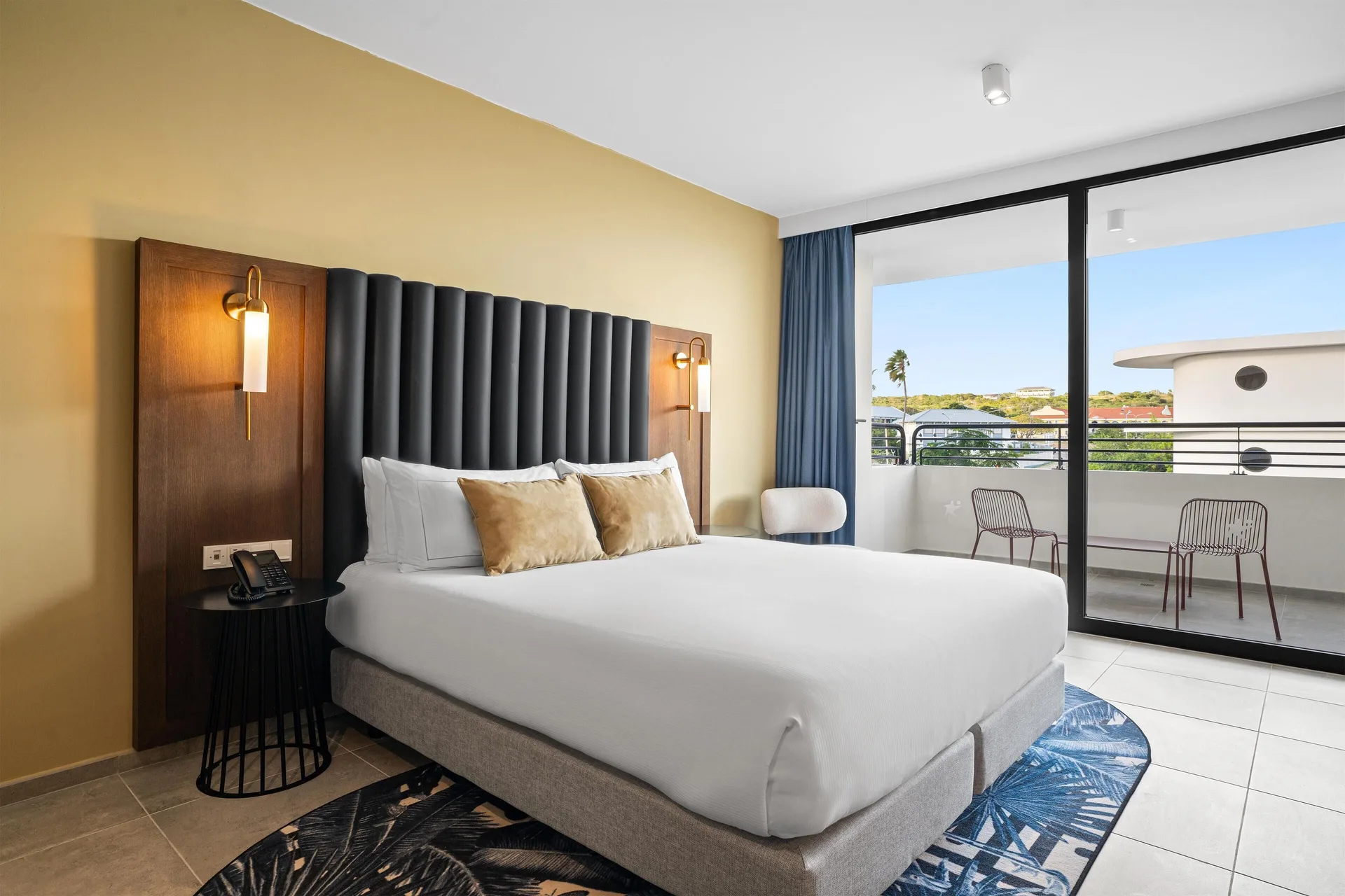 Deluxe Room king bed beside balcony doors at The Rif at Mangrove Beach Corendon Curacao, Curio.