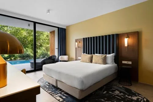 Deluxe Swim Up Room with king bed and swim-up pool outside at The Rif at Mangrove Beach Corendon Curacao, Curio.