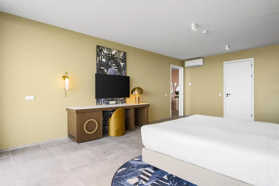 Bedroom with king bed and desk in a Superior Suite at The Rif at Mangrove Beach Corendon Curacao, Curio.