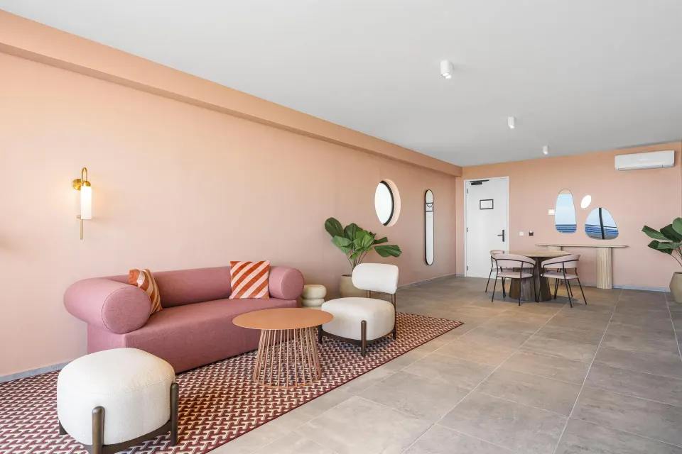Pink sofa seating area in a Superior Suite at The Rif at Mangrove Beach Corendon Curacao, Curio.