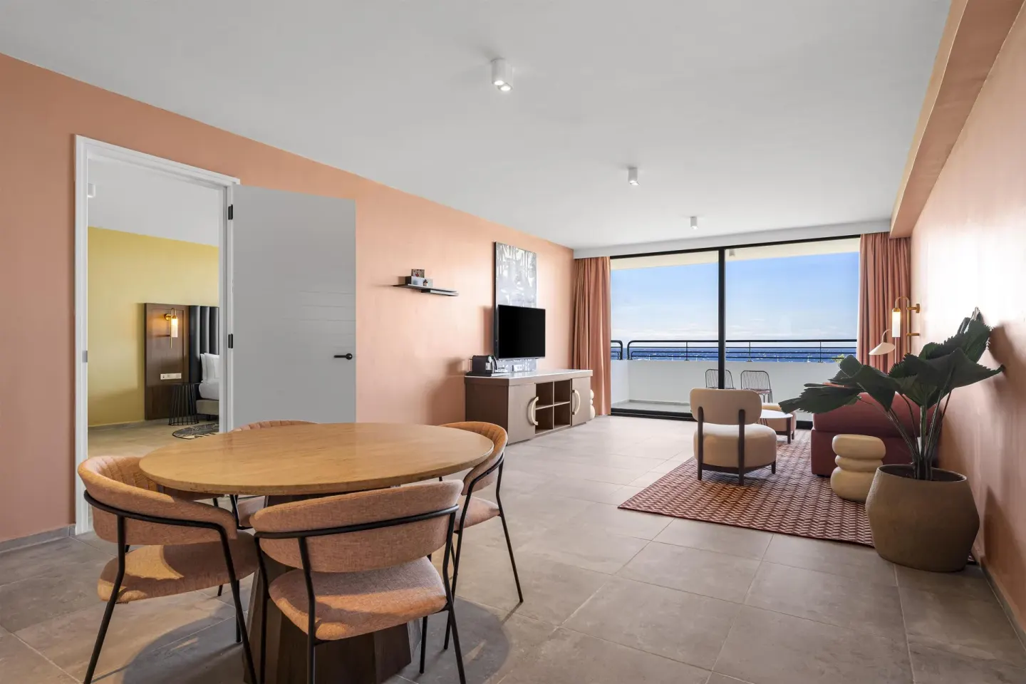 Living and dining area with balcony ocean view in a Superior Suite at The Rif at Mangrove Beach Corendon Curacao, Curio.