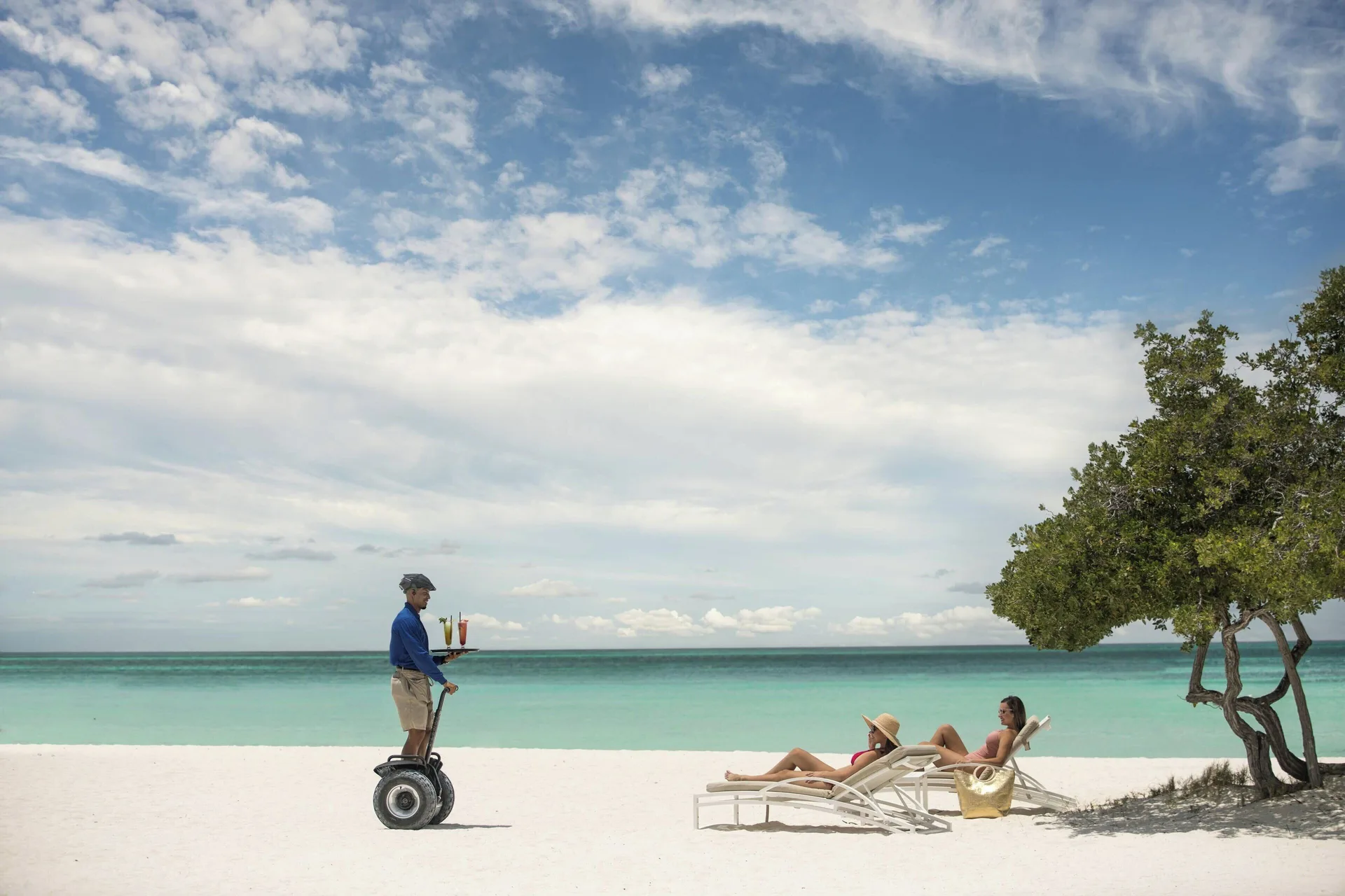 Beach loungers receive drink service on the sand at The Ritz-Carlton, Aruba.