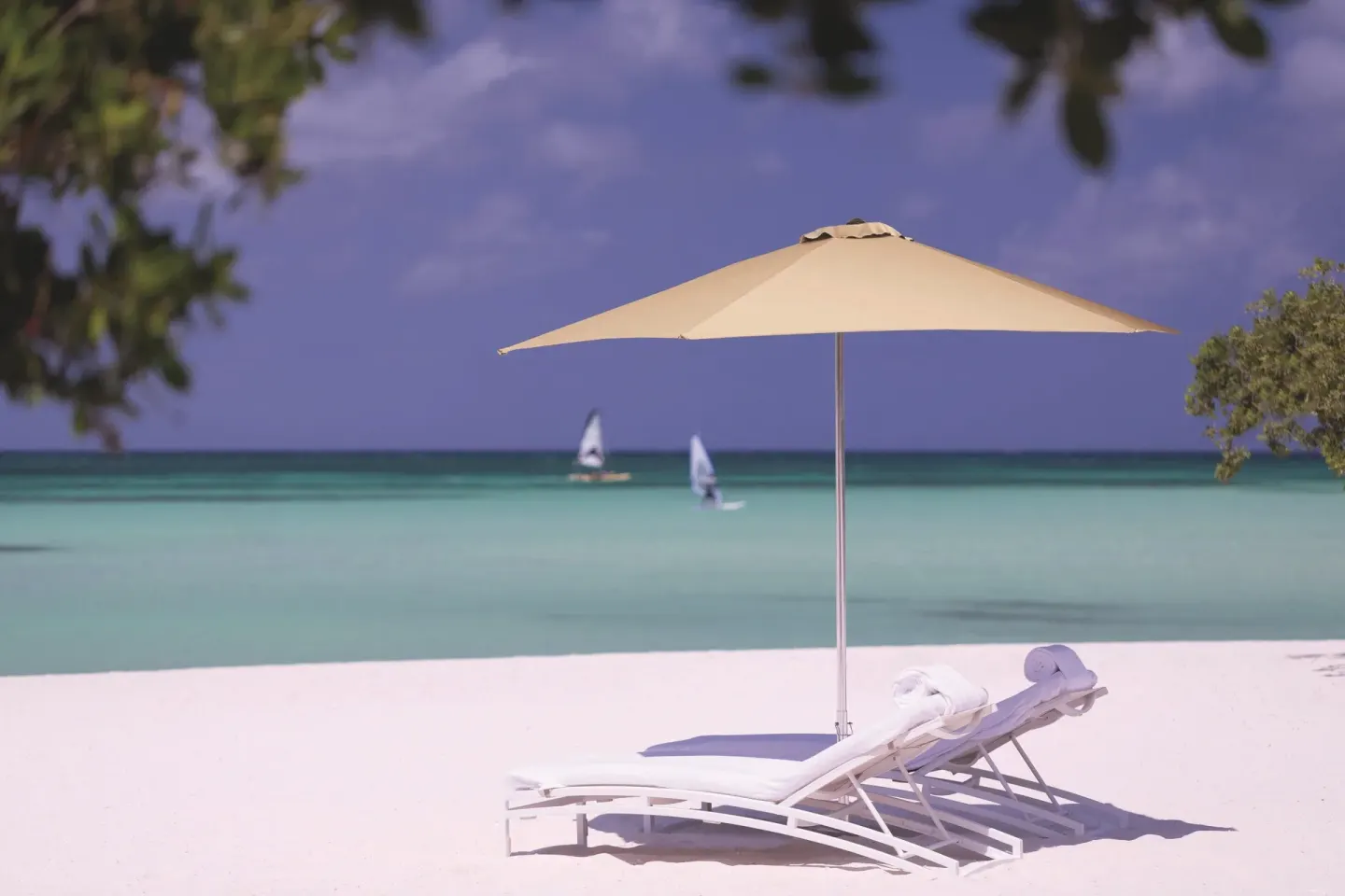 Beach loungers and umbrella face the turquoise sea at The Ritz-Carlton, Aruba.