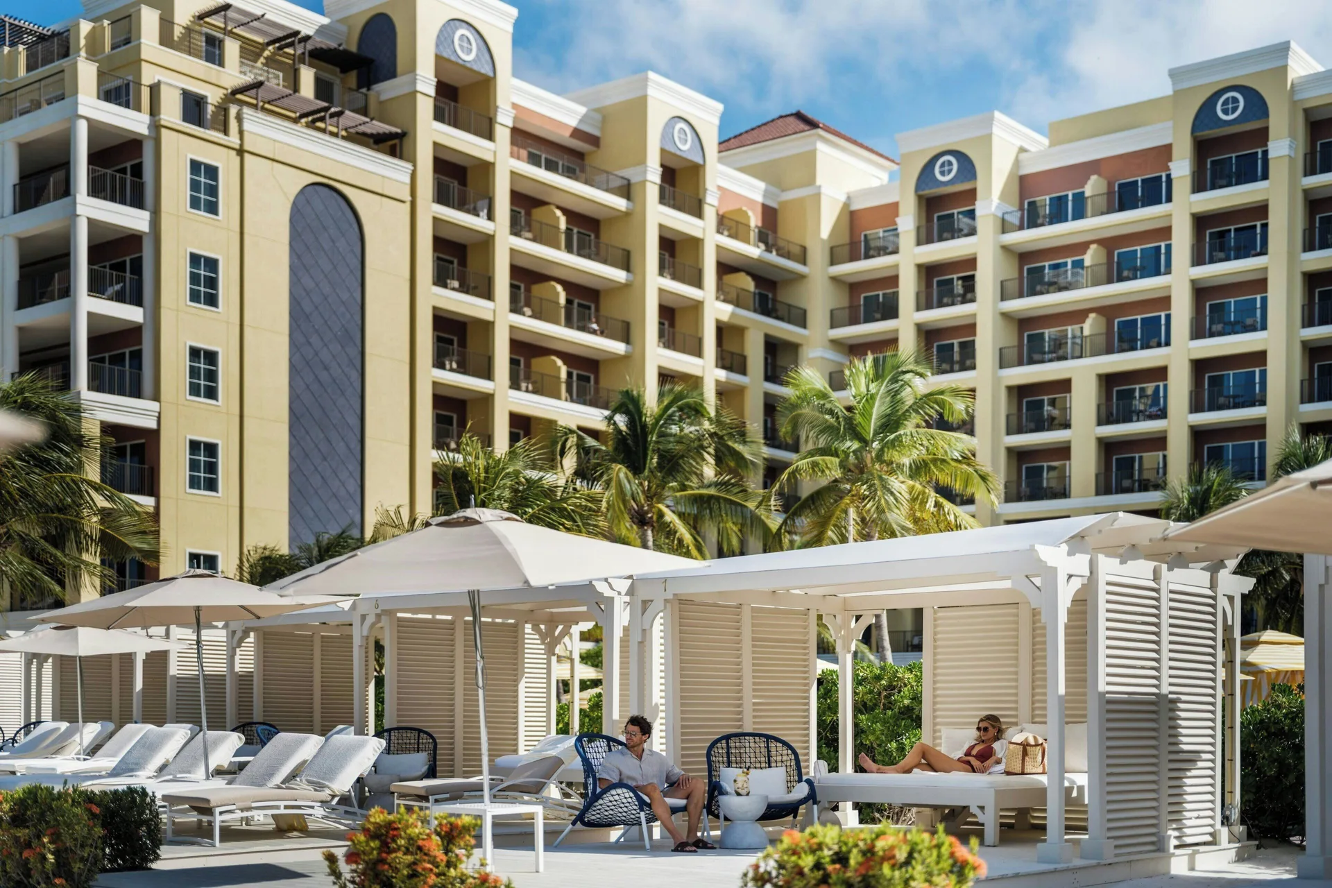 Poolside cabanas and loungers sit below the resort balconies at The Ritz-Carlton, Aruba.