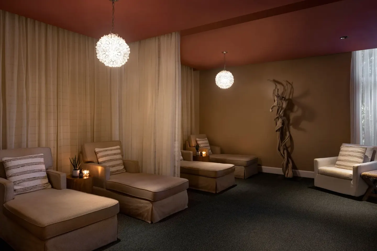 Spa relaxation lounge with chaise seating and pendant lights at The Ritz-Carlton, Aruba.