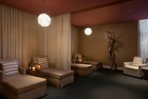 Spa relaxation lounge with chaise seating and pendant lights at The Ritz-Carlton, Aruba.
