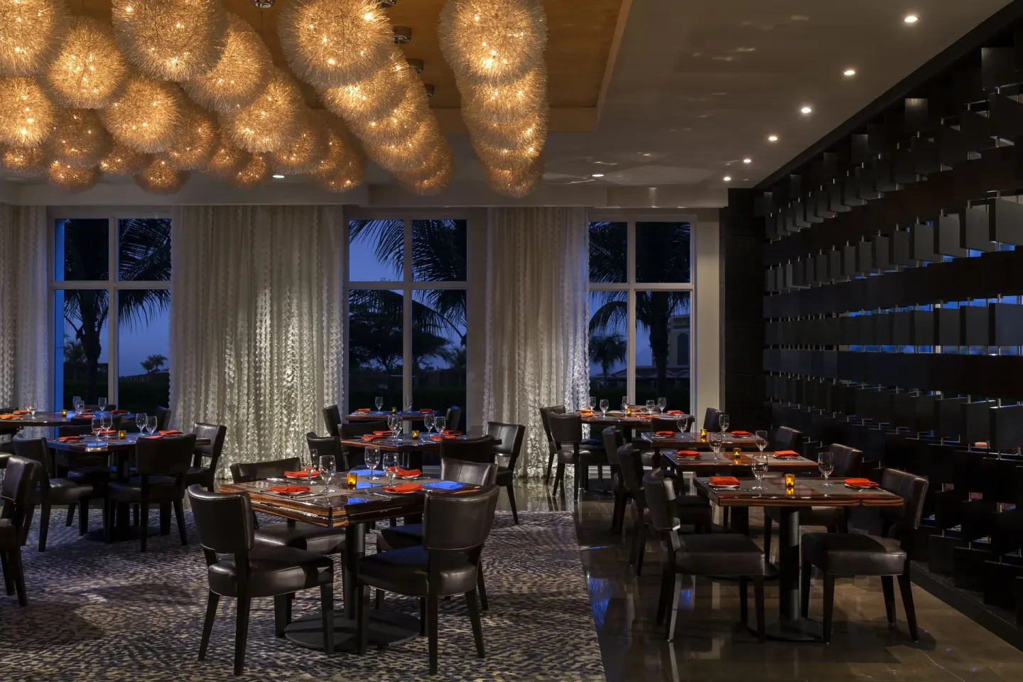 Dining room with glowing pendant lights at The Ritz-Carlton, Aruba.
