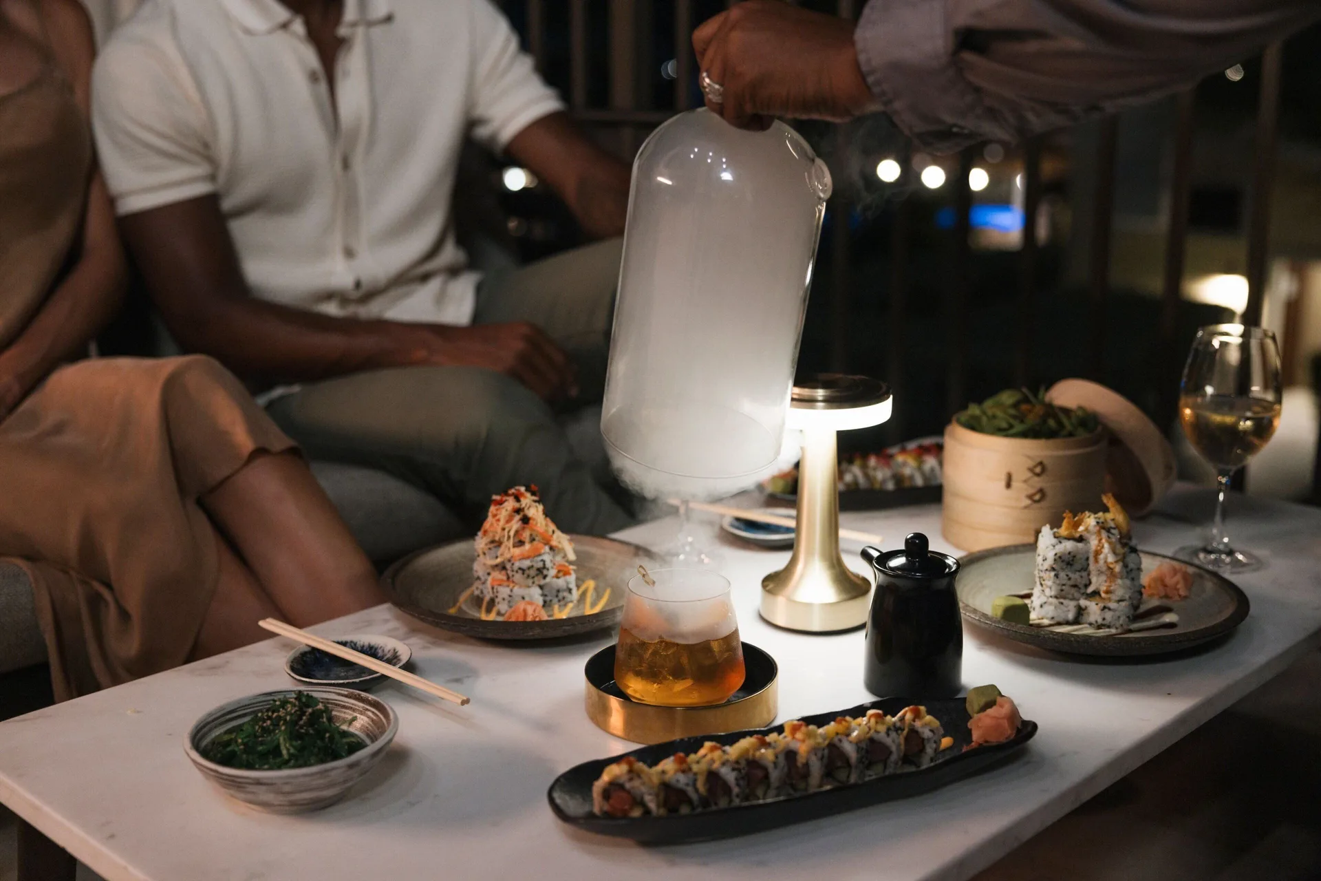Sushi and drinks on a lounge table at The Ritz-Carlton, Aruba with tableside smoke service.
