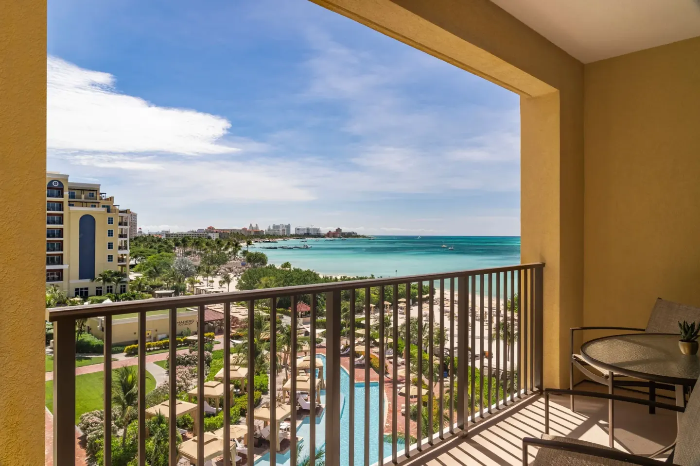 Balcony view of pool, beach, and coastline at The Ritz-Carlton, Aruba.