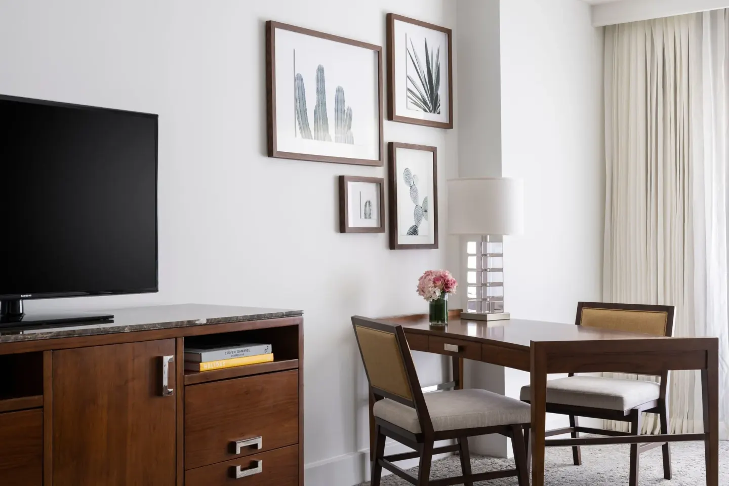 Guest room desk, TV, and botanical wall art at The Ritz-Carlton, Aruba.