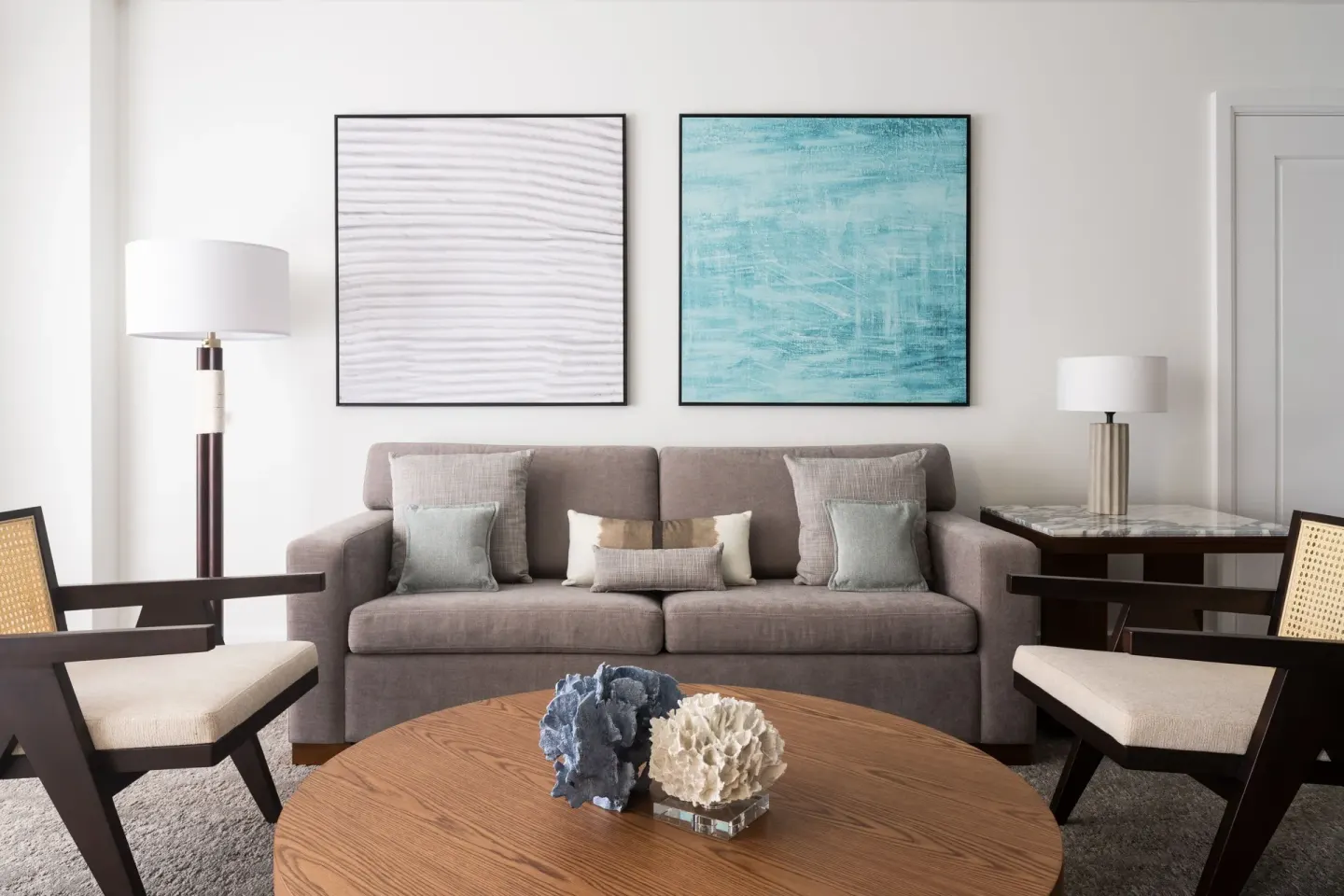 Junior Suite sitting area with sofa, chairs and coastal art at The Ritz-Carlton, Aruba.
